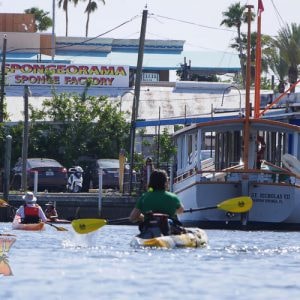 Tarpon sponge docks from the kayak with kayaker heading toward sponge boat.